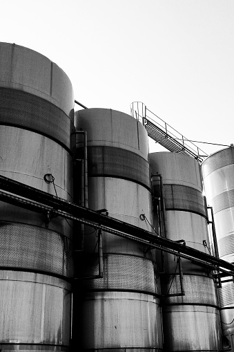 A vertical shot of huge stainless steel tanks in an industrial center