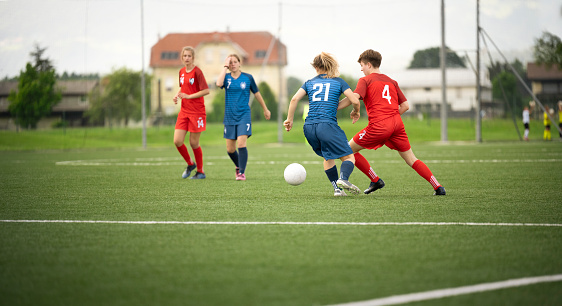 Female football players playing during match on pitch.