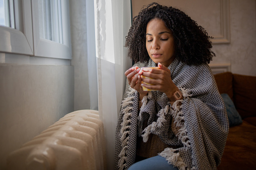 Young woman feel cold in home with no heating