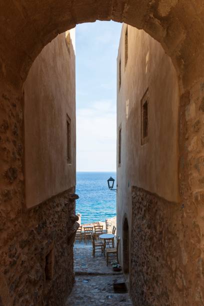 Vertical shot of an arch passage to a famous view in Monemvasia, Greece A vertical shot of an arch passage to a famous view in Monemvasia, Greece monemvasia stock pictures, royalty-free photos & images