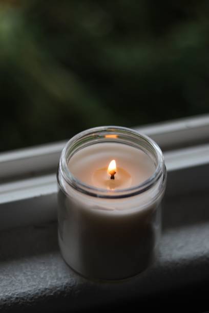 istock Vertical shot of a candle on a shelf next to a window 1432189699