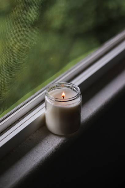 istock Vertical shot of a candle on a shelf next to a window 1432189701