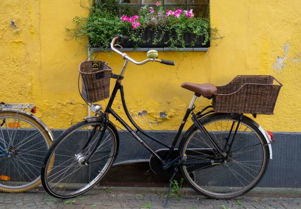 istock Bicycle with wooden baskets on the front and back parked near an old yellow wall 1432190657