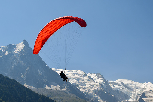 Paraglider flying over town and bir billing mountains. beautiful view of bir-billing mountains paragliding site in himachal pradesh.