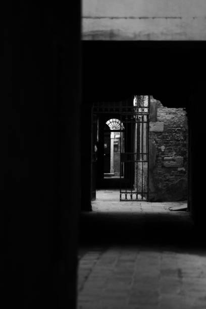istock Vertical grayscale shot of a mysterious corridor in the dark 1432194047