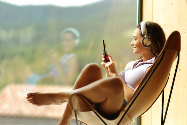 Woman at home or hotel listening to music stock photo