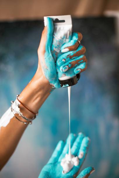 istock Woman dropping cream on her blue painted hands 1432198746