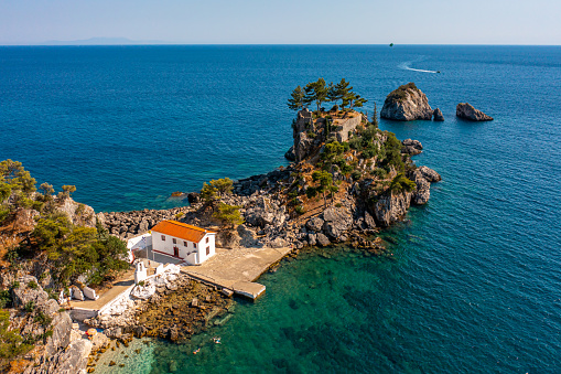 Drone view of old church at island amidst seascape against clear sky during sunny day