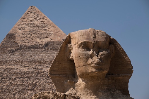 A front view of the Great Sphinx Giza and the Great Pyramid in Egypt under blue sky