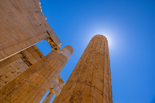 Low angle view of Propylaea gate old ruins against clear blue sky during sunny day