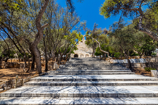 Steps leading towards famous Theater Of Herodes Atticus amidst trees against blue sky