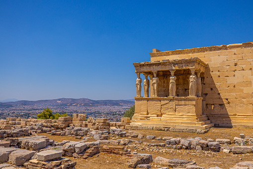 View of ancient Erechtheion temple on Acropolis hill in Athens against clear blue sky