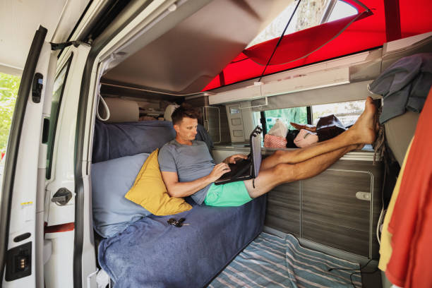istock Man using laptop while comfortably sitting in campervan during vacation 1432206064
