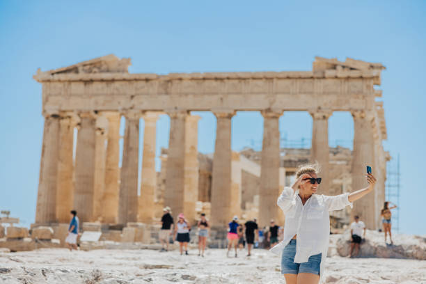 istock Smiling woman taking selfie on cellphone while exploring Parthenon temple 1432206076