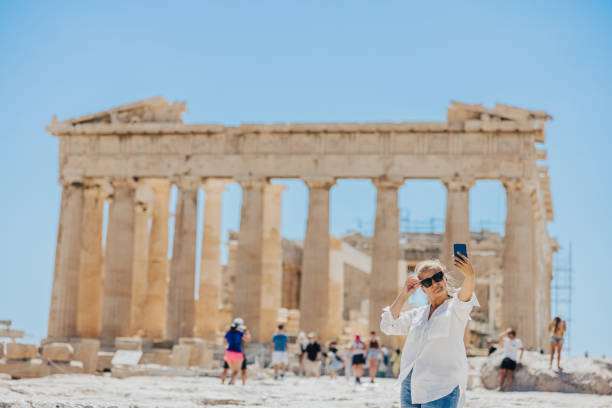 istock Woman taking selfie on smart phone while exploring Parthenon temple against sky 1432206139