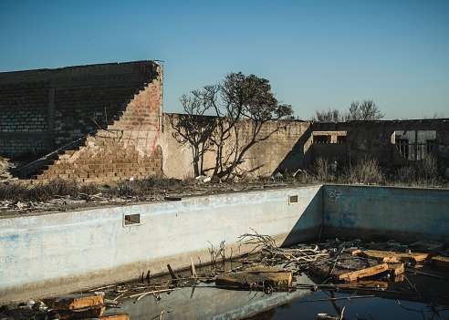 An abandoned dirty pool with ruins inside a house