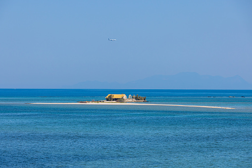 Idyllic view of old small church amidst seascape against clear blue sky during summer