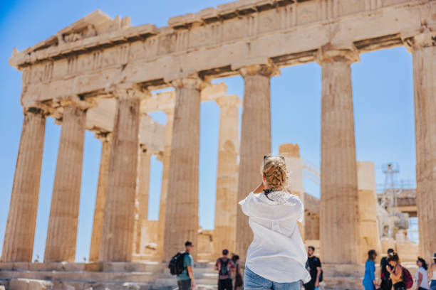 turista femminile che fotografa l'antico tempio del partenone contro il cielo limpido - clear sky acropolis athens greece greece foto e immagini stock