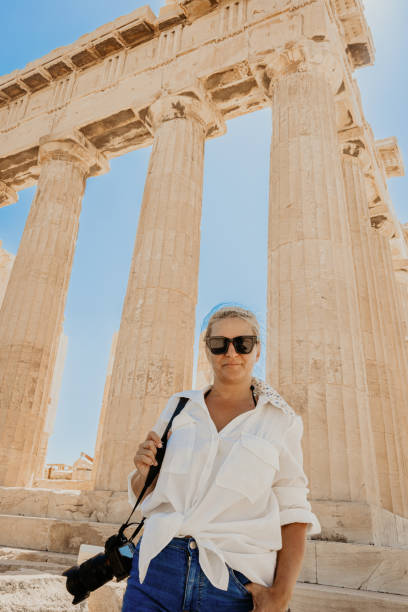 istock Smiling woman with camera exploring ancient Parthenon temple against clear sky 1432206845