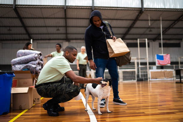 Soldier petting a dog of a refugee man at a community center