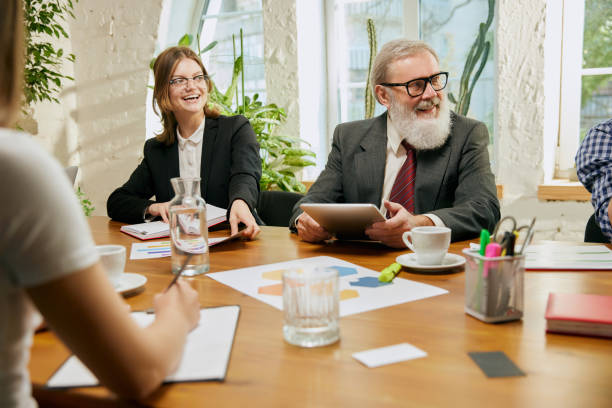 istock Friendly atmosphere at business gathering. Mixed ages people talking, working with colleagues at loft style office space, indoors. 1432207962