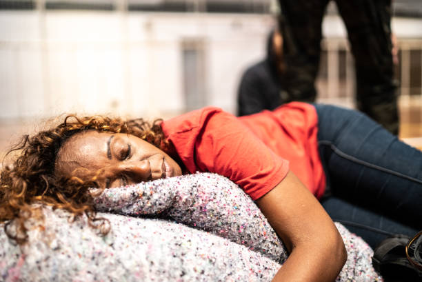 Sick young woman lying on couch with wet towel on her forehead for reduce high fever. Illness and health care concept.