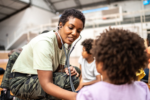 Army doctor examining refugee children at a community center