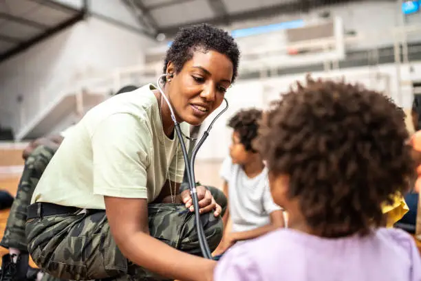 Photo of Army doctor examining refugee children at a community center