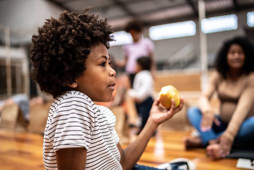 Boy eating an apple at a community center