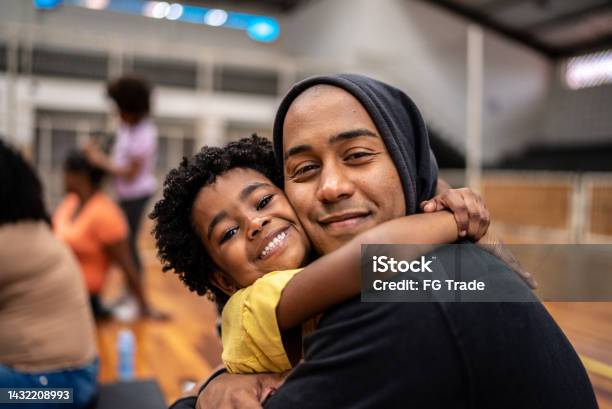 Portrait Of Father And Daughter Embracing At A Community Center Stock Photo - Download Image Now