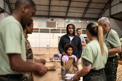Soldiers giving food to people at a community center