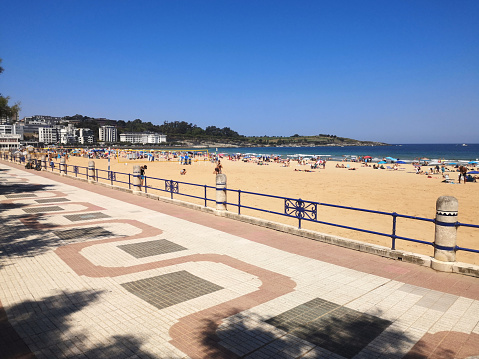 Promenade on the crowded Playa Sardinero in Santander, the capital of the autonomous community and historical region of Cantabria situated on the north coast of Spain.