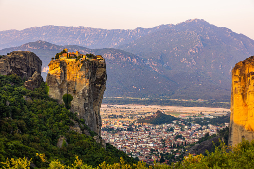 Scenic view of Meteora monastery and cityscape against mountains during sunny day