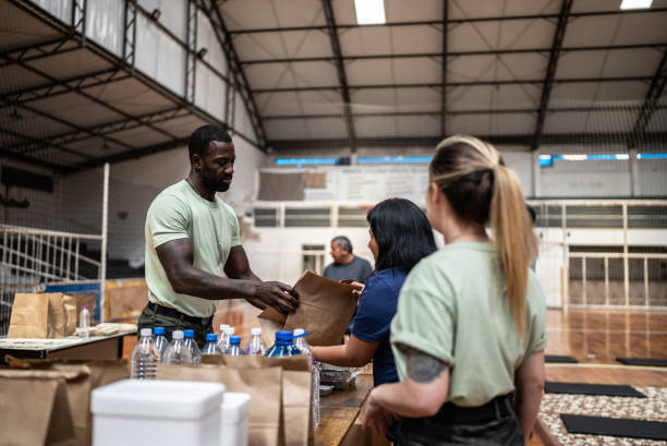 soldados dando donaciones a refugiados en un refugio - department of homeland security fotografías e imágenes de stock