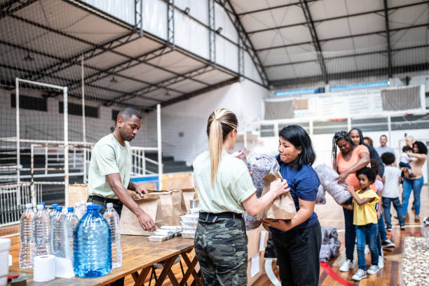 soldados dando donaciones a refugiados en un refugio - department of homeland security fotografías e imágenes de stock