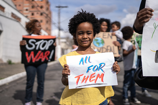 Portrait of a girl holding a banner in a protest in the street