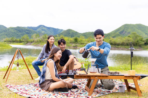 istock Group of Asian people having breakfast drinking coffee while camping together at nature park. 1432215734