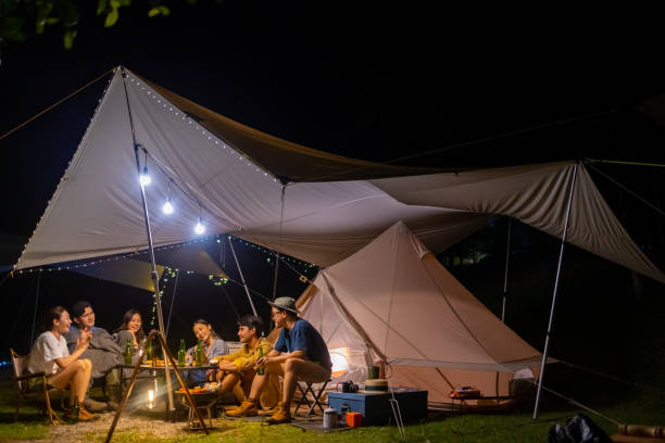istock Group of Asian people cooking and having dinner while camping together at summer night. 1432216018