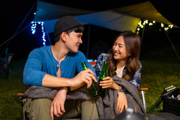 istock Group of Asian people cooking and having dinner while camping together at summer night. 1432216087