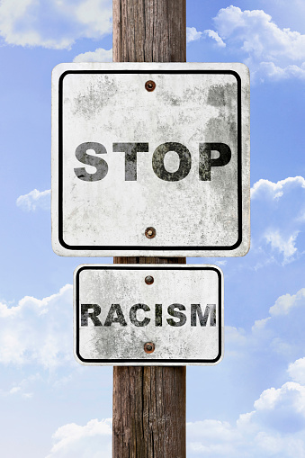 Stop racism sign with blue sky