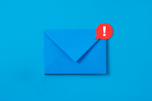 Blue envelope with exclamation mark symbol attached on it on blue background