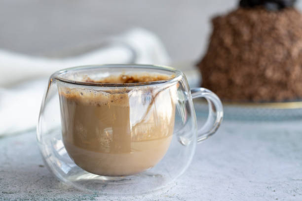 istock Coffee mug on gray background. Coffee with cake in the background. close up 1432219864