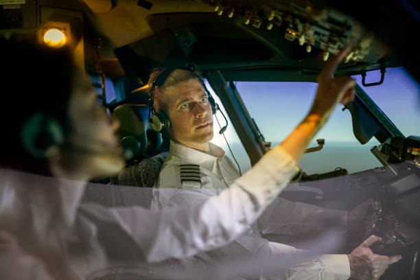 instructor watches female trainee pilot adjusting switches during simulator training - avionics flying training cockpit imagens e fotografias de stock