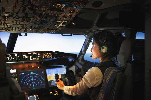 rückansicht einer pilotin, die ein flugzeug fliegt - airplane electronics industry air vehicle cockpit stock-fotos und bilder