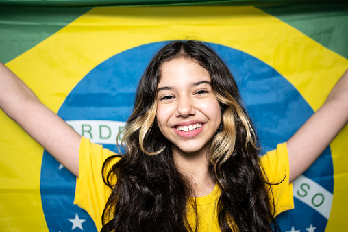 Portrait of a Brazilian female fan celebrating on yellow uniform