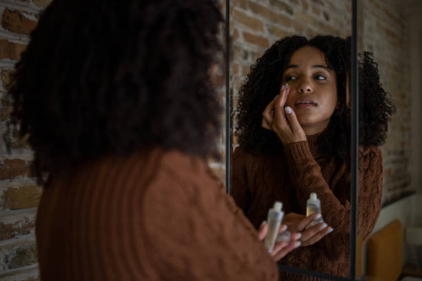 istock Handsome woman applying moisturizer to his face 1432221923