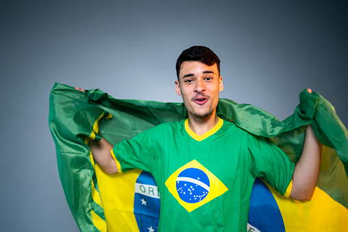 Brazilian young man fan celebrating on green uniform