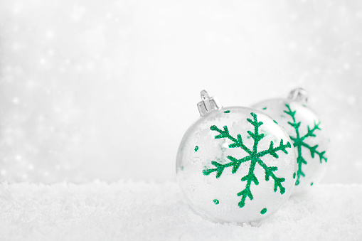 Christmas baubles on snowy white defocused background