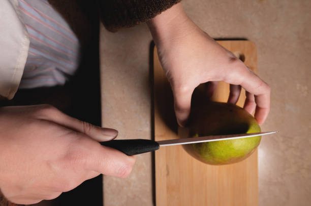istock Top view woman cutting fruit on wooden board on table 1432224264