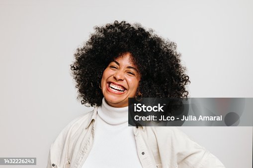istock Happy young woman of color smiling at the camera in a studio 1432226243